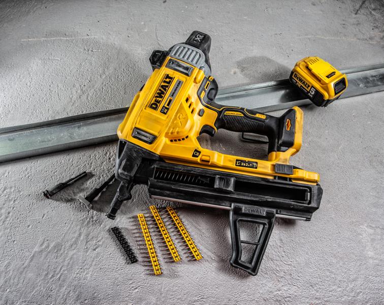 DEWALT DCN890P2 accuspijker met accessoires en bevestigingsmateriaal op betonoppervlak.