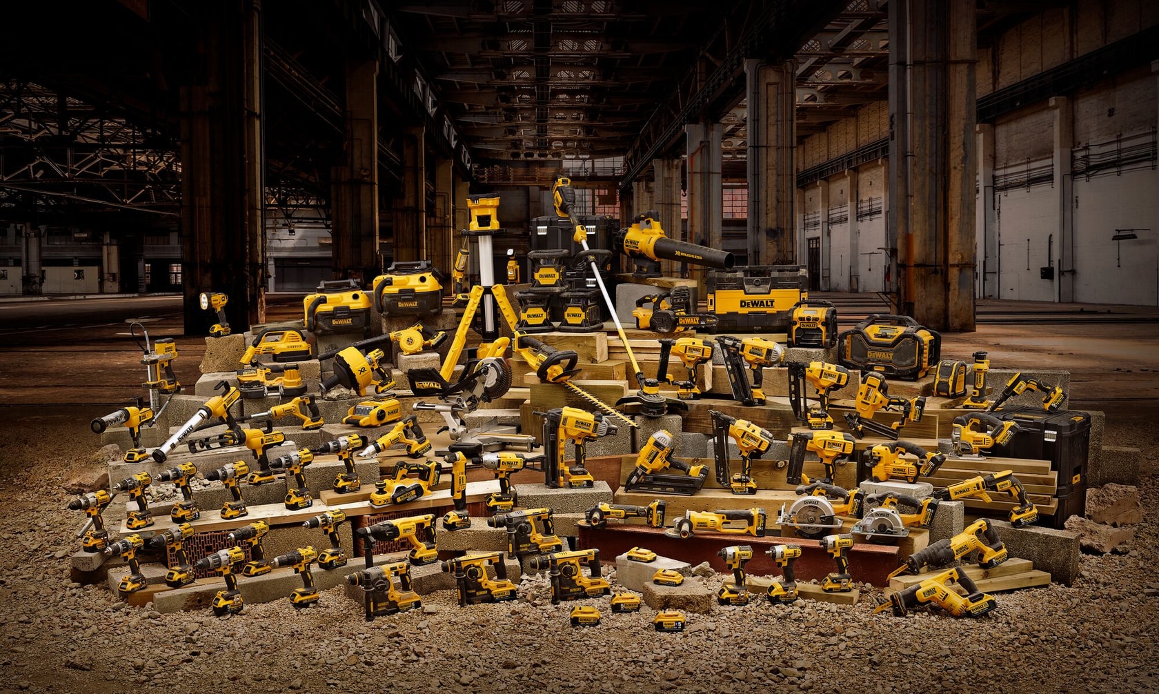 Various DEWALT yellow power tools and cases displayed in an industrial warehouse setting.